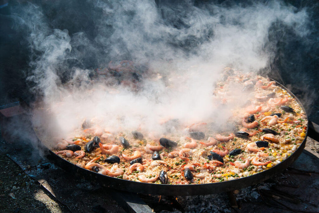 What ingredients give flavor to paella?